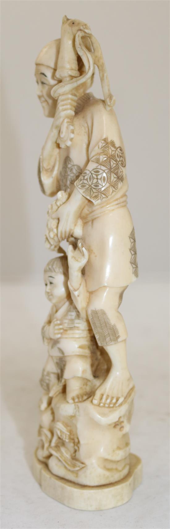 A Japanese walrus ivory okimono of a man and a boy, early 20th century, 23.5cm